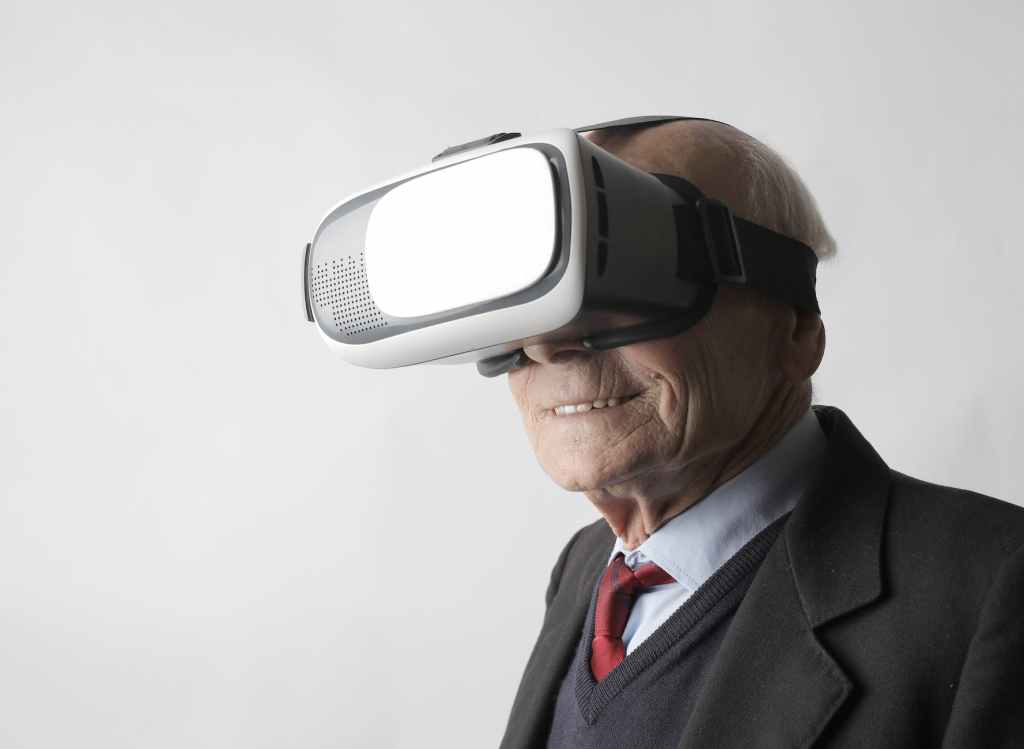 senior man using vr goggles in studio