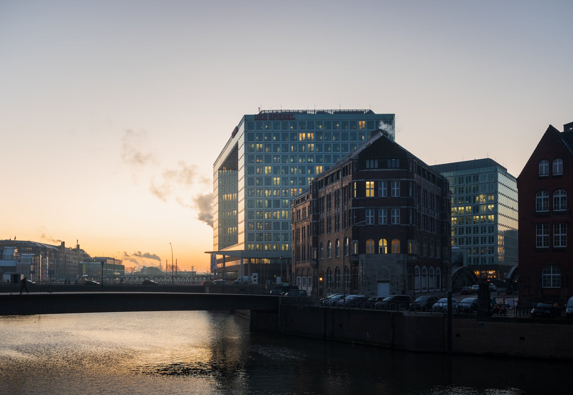a river with buildings in the background at sunset