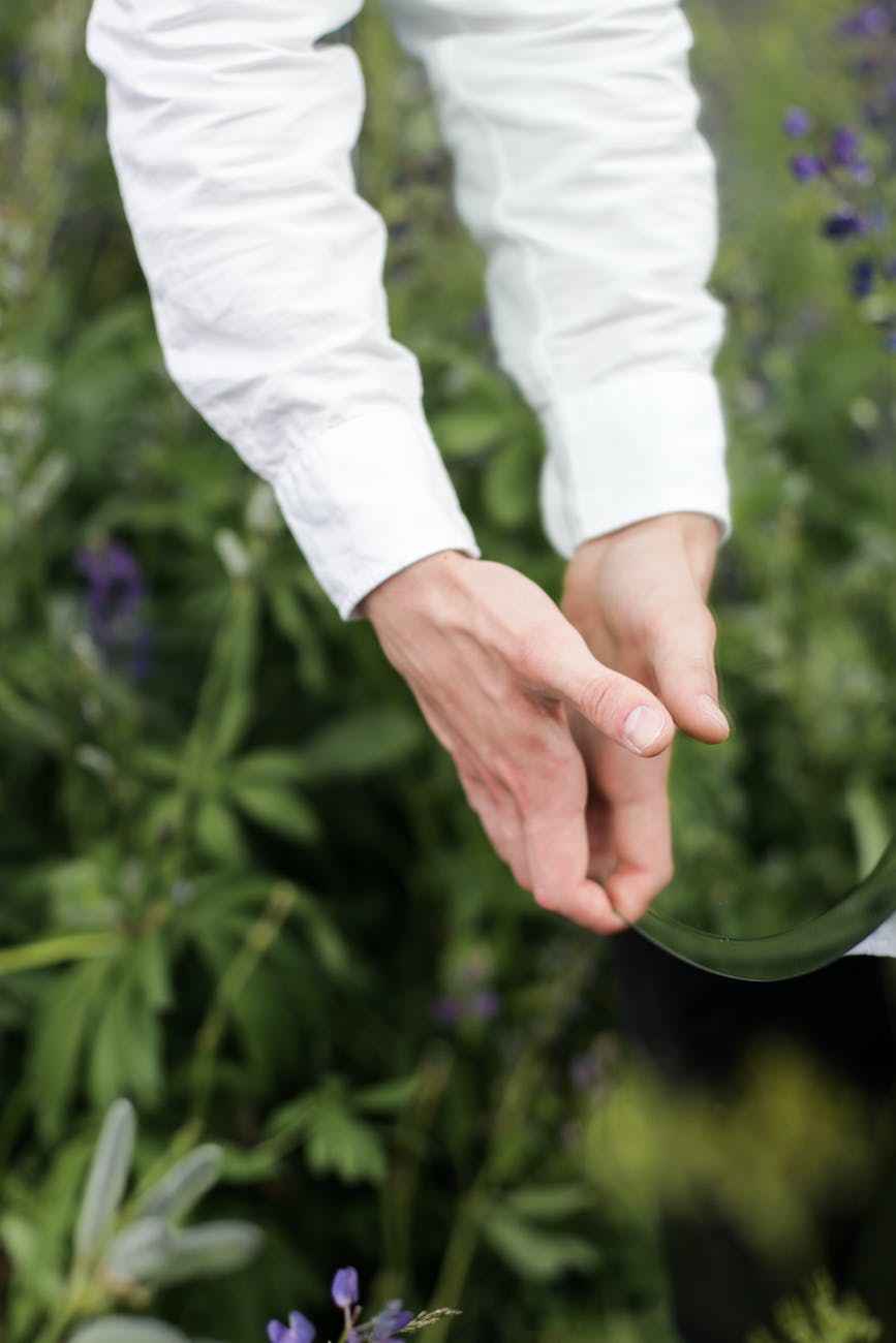 person in white pants and white long sleeve shirt holding hands