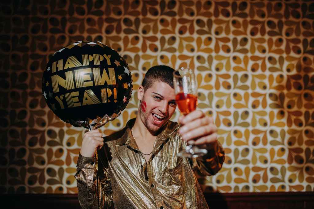 man holding champagne glass and balloon