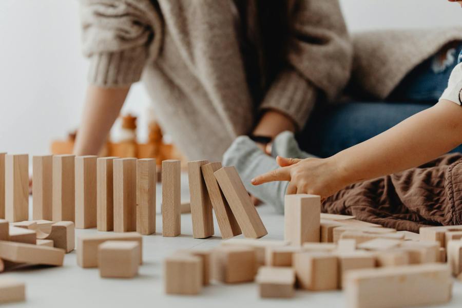 photo of a child s hand tipping wooden blocks